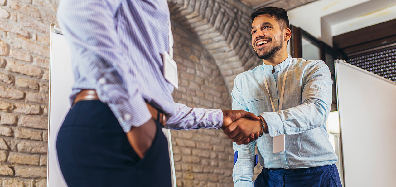 Un homme d’affaires avec une béquille serre la main de son collègue.