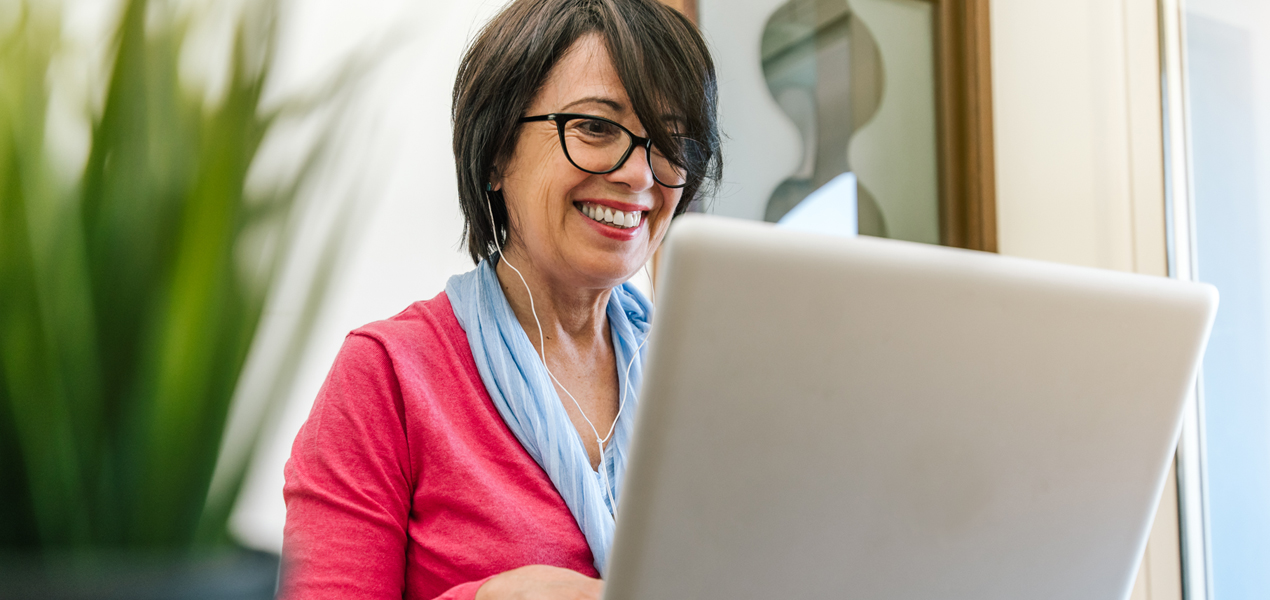 Femme mûre portant un casque, travaillant sur un ordinateur portable