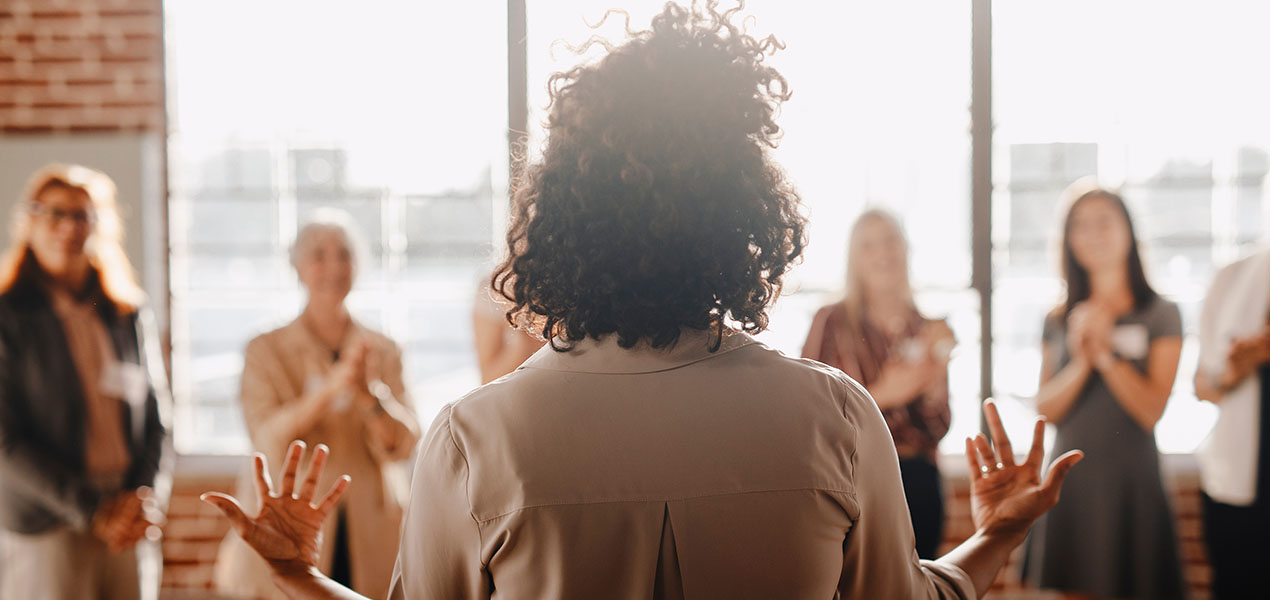 Un groupe de femmes écoutent attentivement une conférencière.