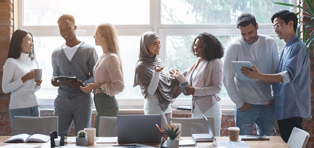 Équipe d’affaires debout près d’une table de réunion et discutant entre eux.